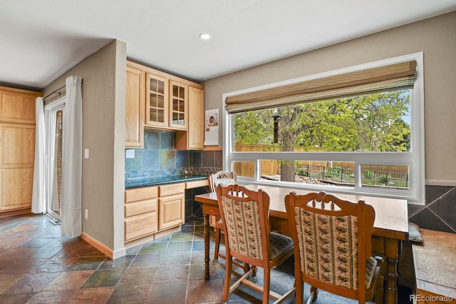 kitchen with healthy amount of natural light, decorative backsplash, baseboards, glass insert cabinets, and recessed lighting