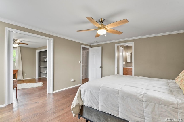 bedroom featuring baseboards, ornamental molding, wood finished floors, a ceiling fan, and ensuite bath