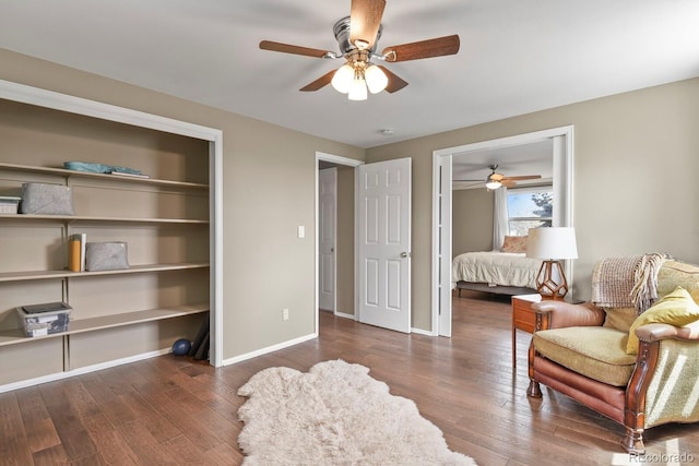 living area featuring a ceiling fan, wood finished floors, and baseboards
