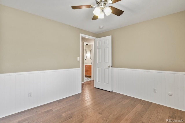 spare room with wainscoting, ceiling fan, hardwood / wood-style floors, and a smoke detector