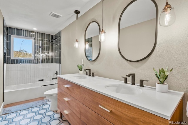 full bathroom with toilet, double vanity, shower / washtub combination, a textured wall, and tile patterned flooring