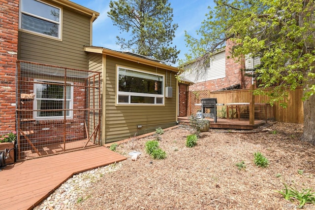 back of house featuring fence and a wooden deck