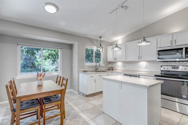 2602 Cove Creek Ct, Highlands Ranch, CO 80129 - kitchen with appliances with stainless steel finishes, light countertops, decorative backsplash, a center island, and white cabinetry