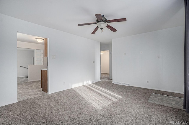 carpeted empty room with visible vents and ceiling fan