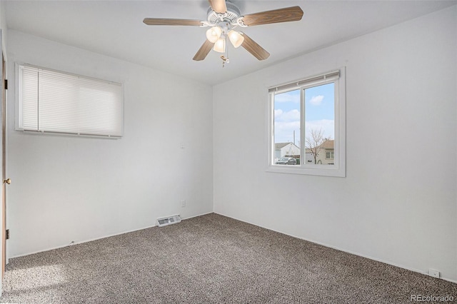 unfurnished room featuring visible vents, carpet, and a ceiling fan