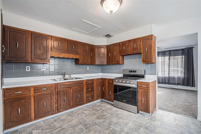 kitchen featuring light countertops, visible vents, stainless steel gas range, and a sink