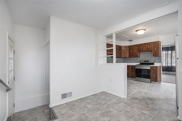 kitchen featuring visible vents, tasteful backsplash, appliances with stainless steel finishes, light countertops, and baseboards