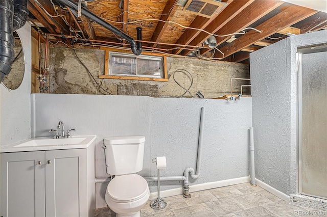 bathroom featuring visible vents, toilet, vanity, and a walk in shower
