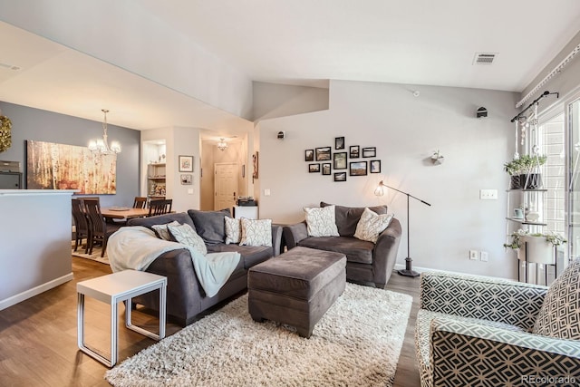 7409 S Alkire St Unit 304, Littleton, CO 80127 - living room with wood finished floors, a chandelier, and lofted ceiling