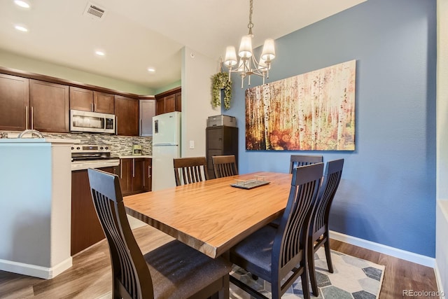 7409 S Alkire St Unit 304, Littleton, CO 80127 - dining area featuring light wood-type flooring, a chandelier, and recessed lighting
