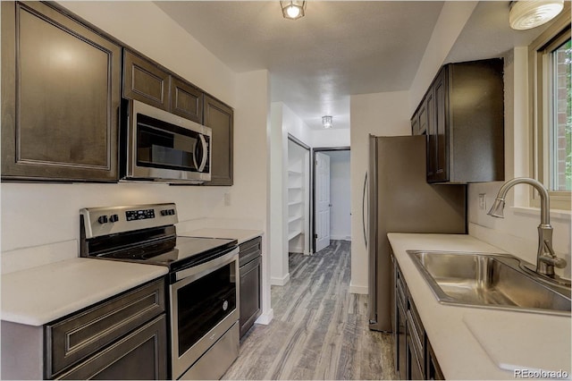 kitchen featuring light hardwood / wood-style floors, sink, a healthy amount of sunlight, and appliances with stainless steel finishes