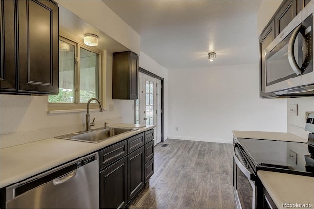 kitchen with stainless steel appliances, light hardwood / wood-style flooring, a healthy amount of sunlight, and sink