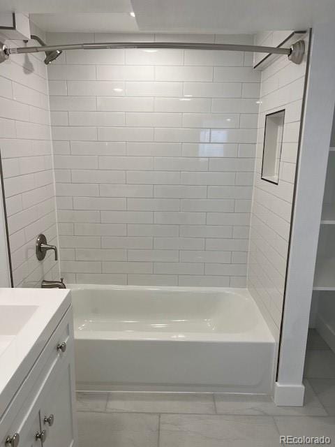 bathroom featuring vanity and tiled shower / bath