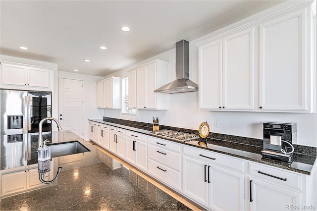 kitchen with white cabinets, wall chimney exhaust hood, a sink, appliances with stainless steel finishes, and recessed lighting