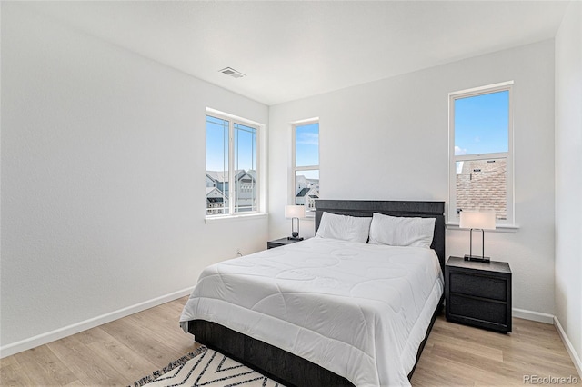 bedroom with visible vents, baseboards, and light wood-style flooring
