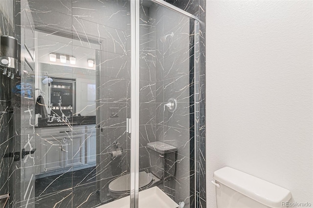 full bath with a marble finish shower and toilet