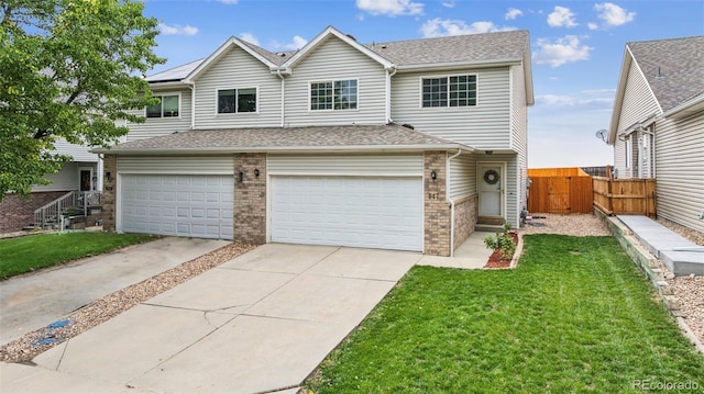 647 Berwick Ave, Firestone, CO 80520 - traditional-style house featuring an attached garage, brick siding, driveway, and a gate