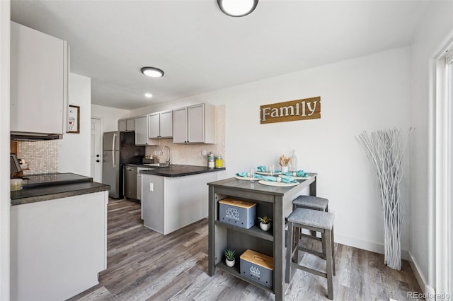 647 Berwick Ave, Firestone, CO 80520 - kitchen with decorative backsplash, dark countertops, wood finished floors, and gray cabinetry