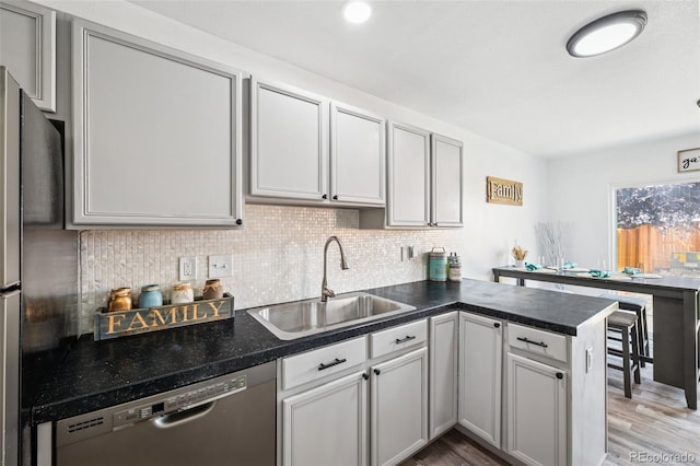 647 Berwick Ave, Firestone, CO 80520 - kitchen featuring stainless steel dishwasher, a peninsula, dark countertops, decorative backsplash, and recessed lighting