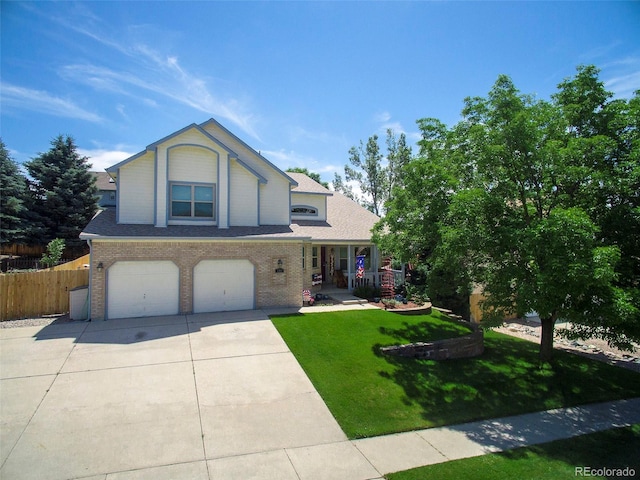 view of front of home with a front lawn, covered porch, and a garage