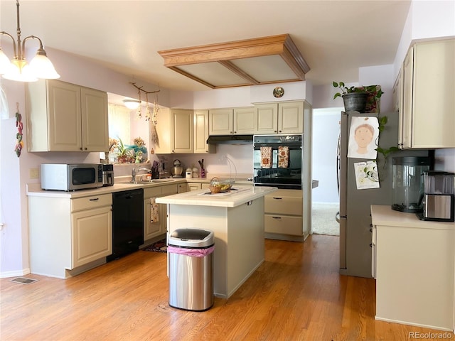 kitchen with sink, black appliances, pendant lighting, a notable chandelier, and a center island