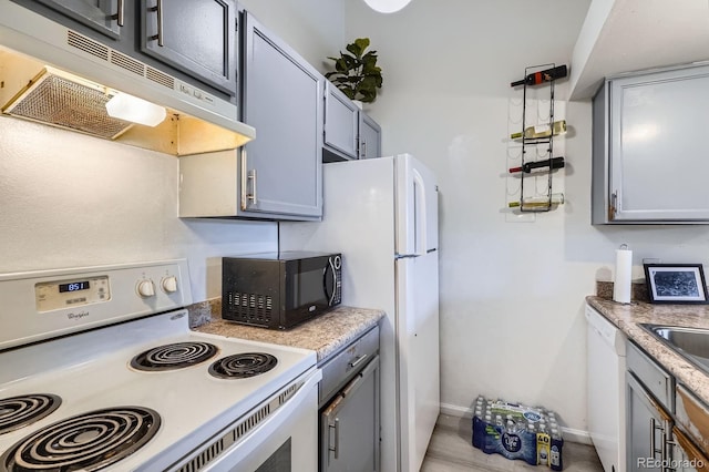 497 S Memphis Way Unit 17, Aurora, CO 80017 - kitchen with white appliances, under cabinet range hood, and light countertops