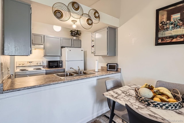 497 S Memphis Way Unit 17, Aurora, CO 80017 - kitchen with white appliances, under cabinet range hood, a peninsula, and gray cabinets