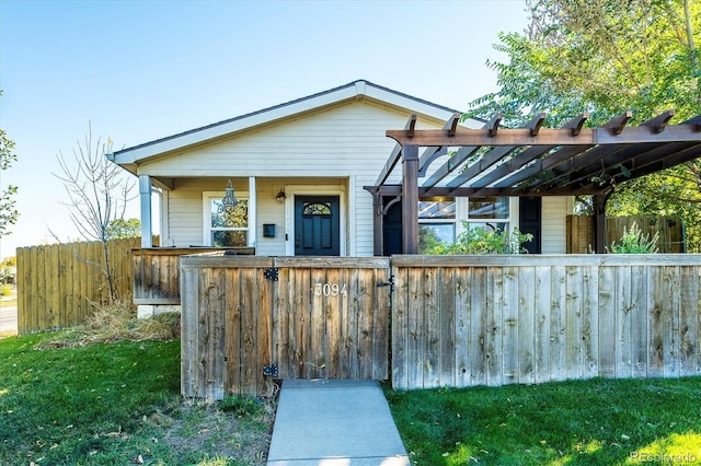 view of front facade with a front yard and a pergola