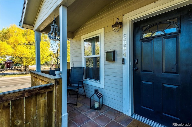 view of exterior entry featuring covered porch