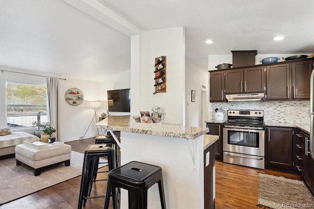 kitchen featuring dark brown cabinets, a kitchen breakfast bar, stainless steel electric range, lofted ceiling, and dark wood-type flooring