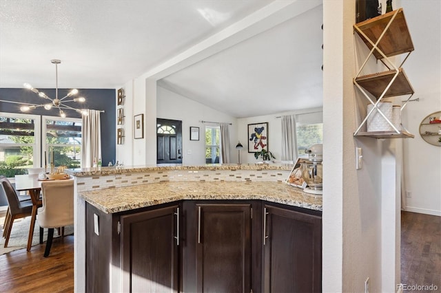 kitchen featuring dark hardwood / wood-style flooring, dark brown cabinetry, a healthy amount of sunlight, and vaulted ceiling