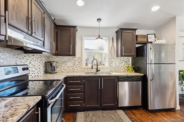 kitchen featuring hanging light fixtures, appliances with stainless steel finishes, dark wood-type flooring, dark brown cabinetry, and sink