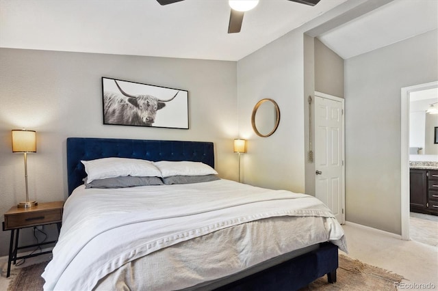 carpeted bedroom with ensuite bath, ceiling fan, and vaulted ceiling