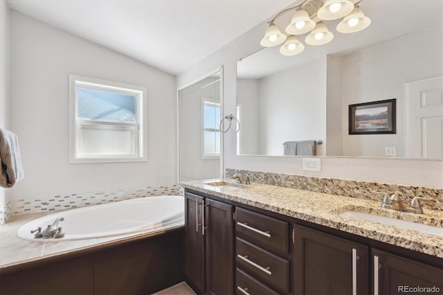 bathroom with vanity, vaulted ceiling, and a bathing tub