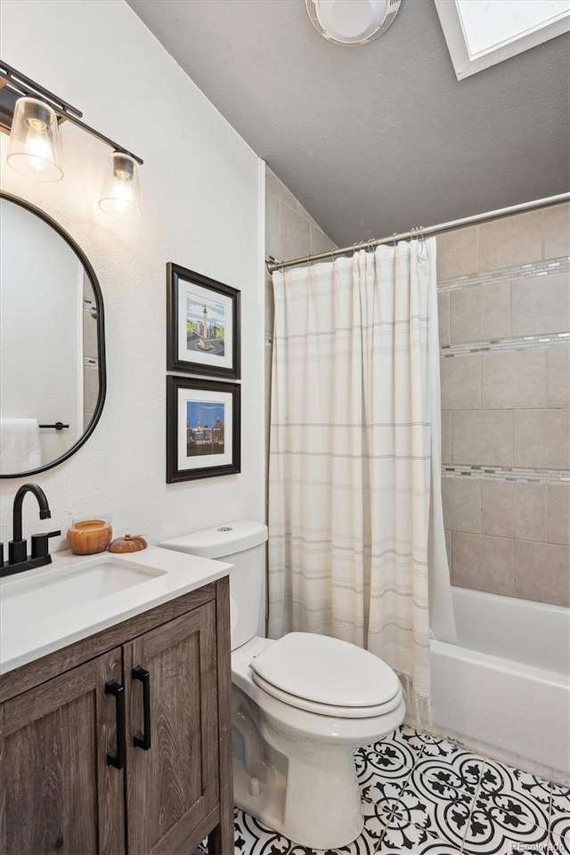 full bathroom with toilet, tile patterned flooring, shower / bath combo with shower curtain, vanity, and a textured ceiling