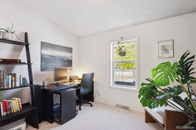 carpeted home office featuring vaulted ceiling