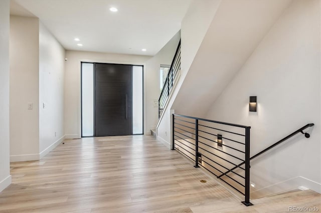 foyer entrance with light wood finished floors, baseboards, and recessed lighting