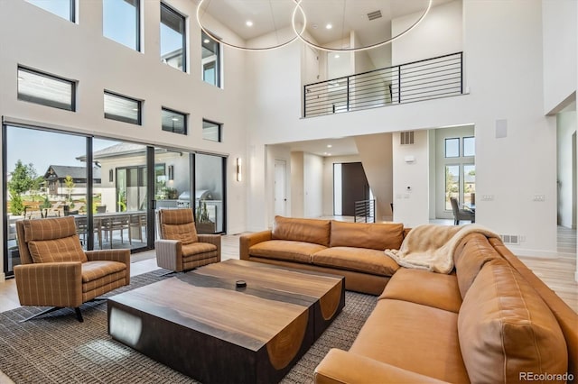 living area featuring baseboards, visible vents, and wood finished floors