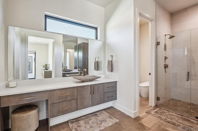 bathroom featuring a shower stall, baseboards, vanity, and toilet