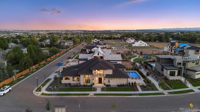 aerial view at dusk featuring a residential view