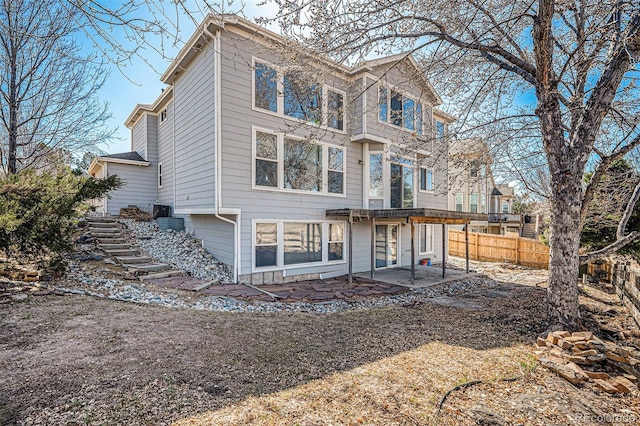 back of property with a patio, stairs, and fence