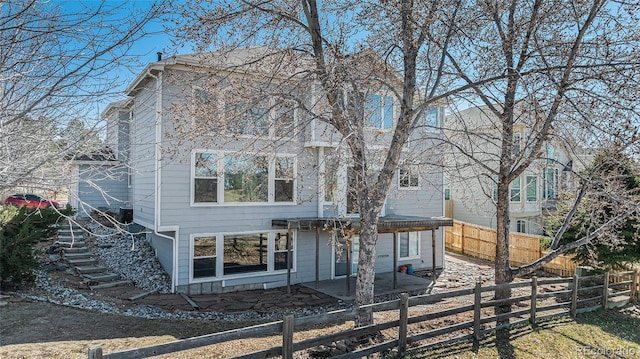 rear view of house with a patio area, stairway, and fence private yard