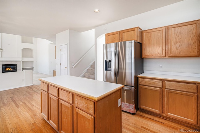 kitchen featuring light countertops, light wood-type flooring, and stainless steel fridge with ice dispenser