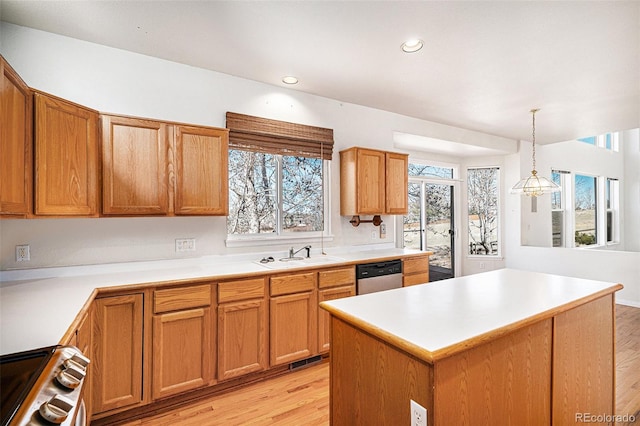 kitchen with a sink, light countertops, light wood-style flooring, and stainless steel appliances