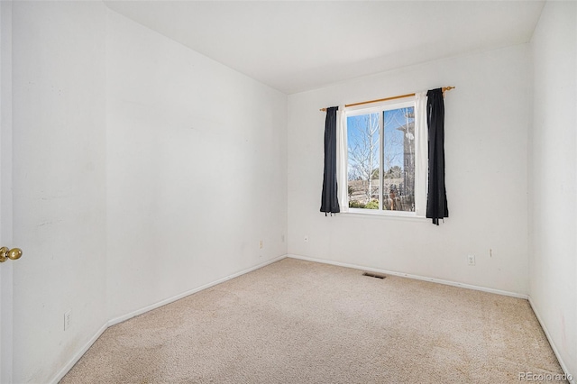 carpeted empty room featuring baseboards and visible vents