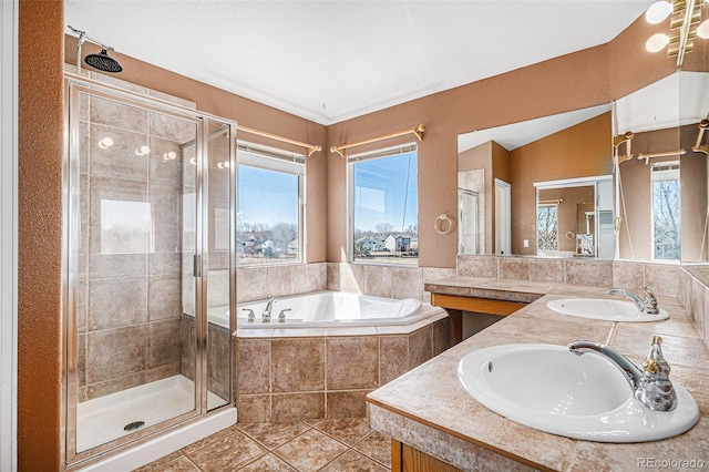 full bathroom featuring a bath, tile patterned floors, a stall shower, and a sink