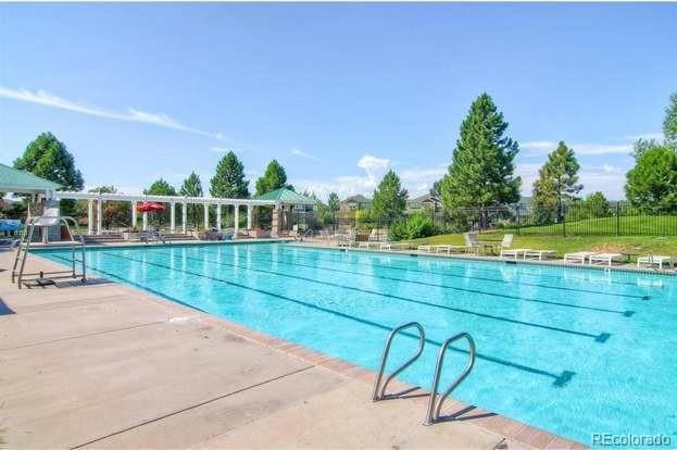 community pool with a patio area and fence