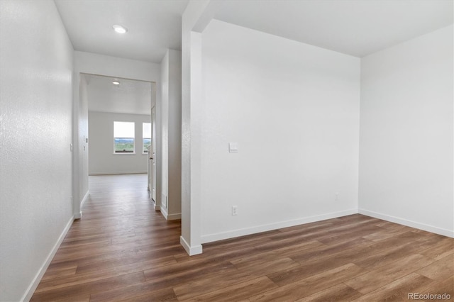 corridor with dark wood finished floors and baseboards