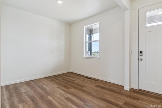 foyer featuring visible vents, baseboards, and wood finished floors