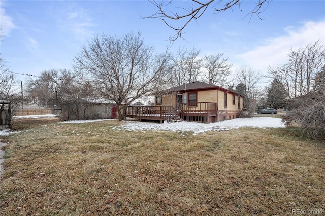 exterior space with a deck, brick siding, and a lawn